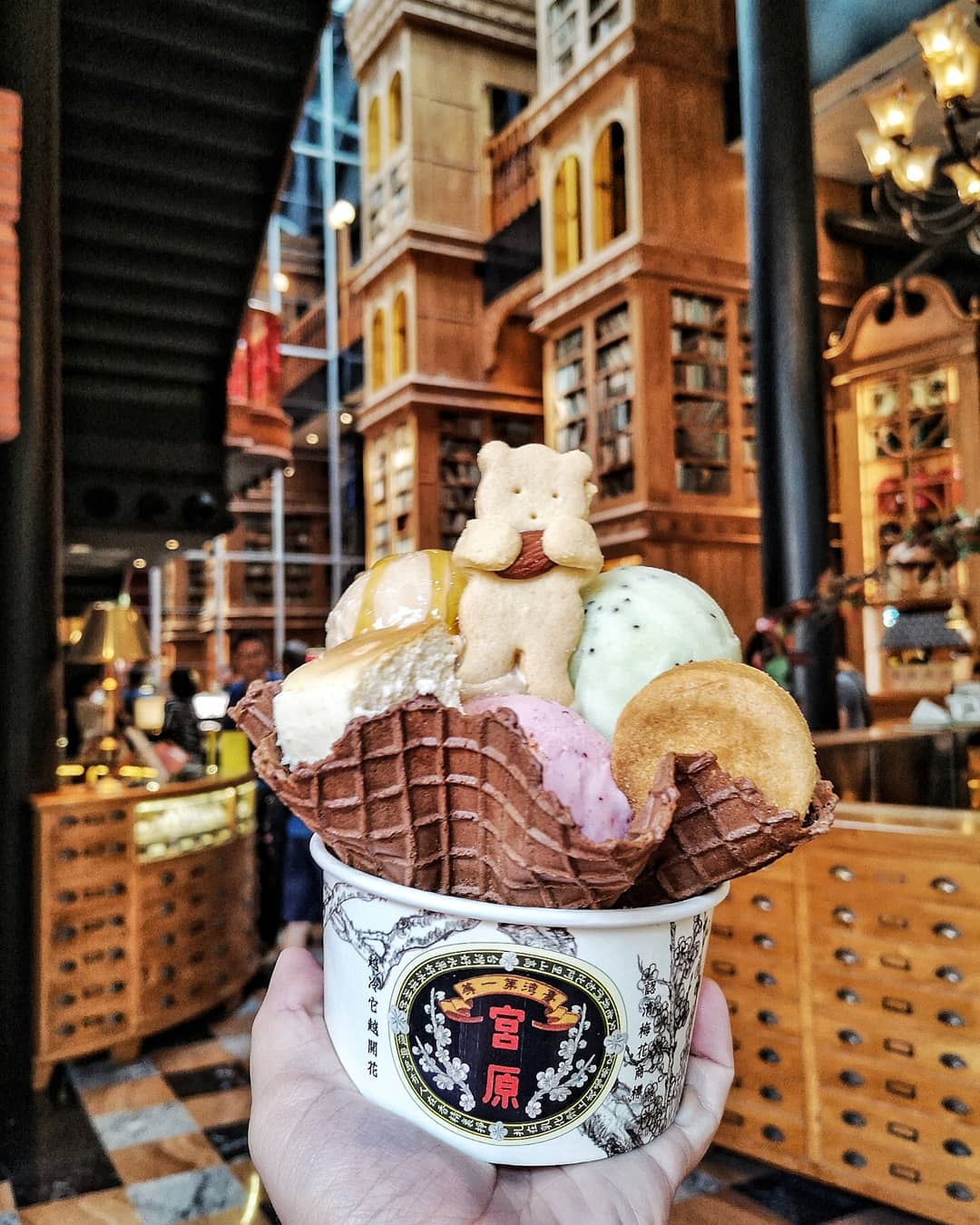 ice cream cup with a waffle cone holds four colorful scoops and a cute bear-shaped cookie