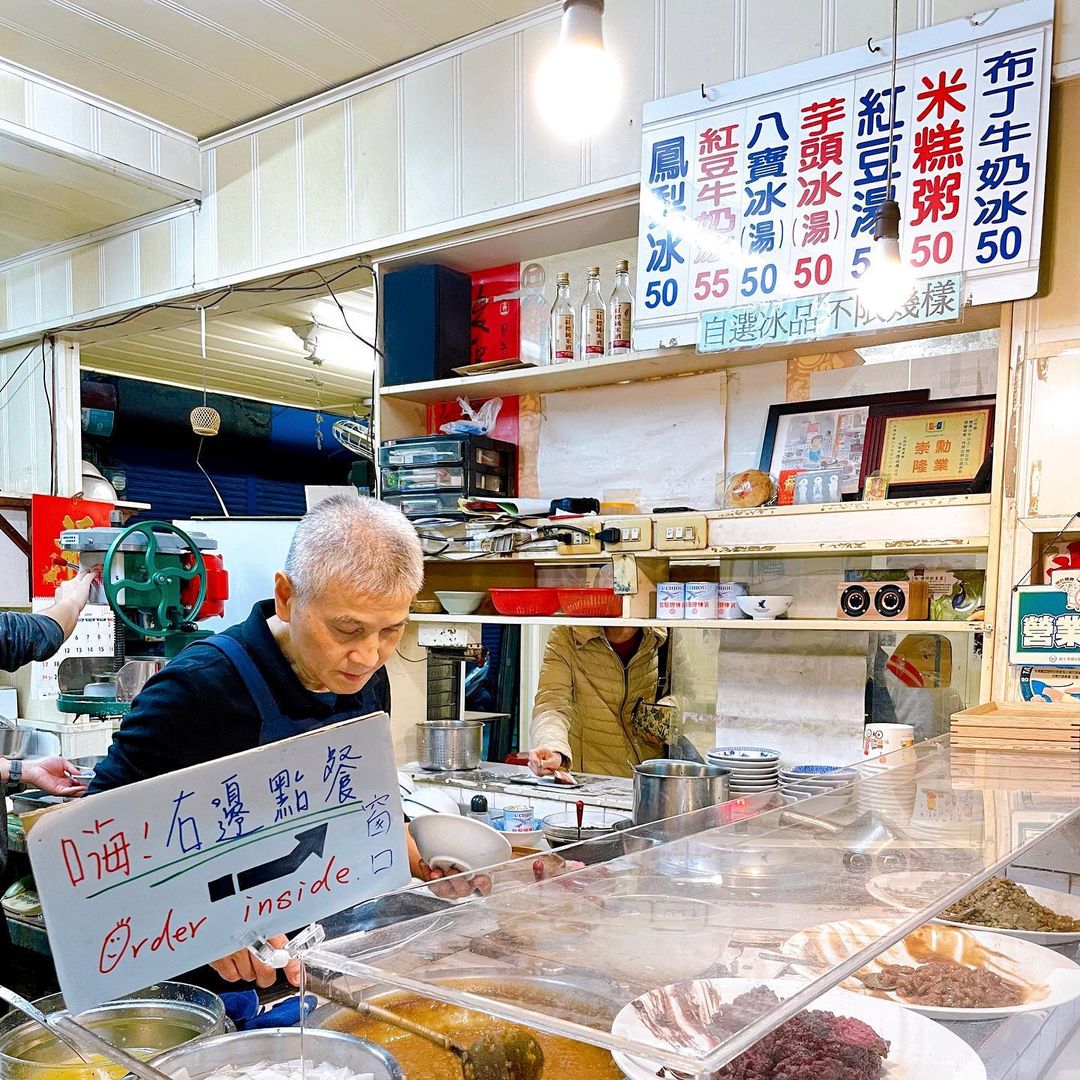 A vendor prepares food at a bustling market stall