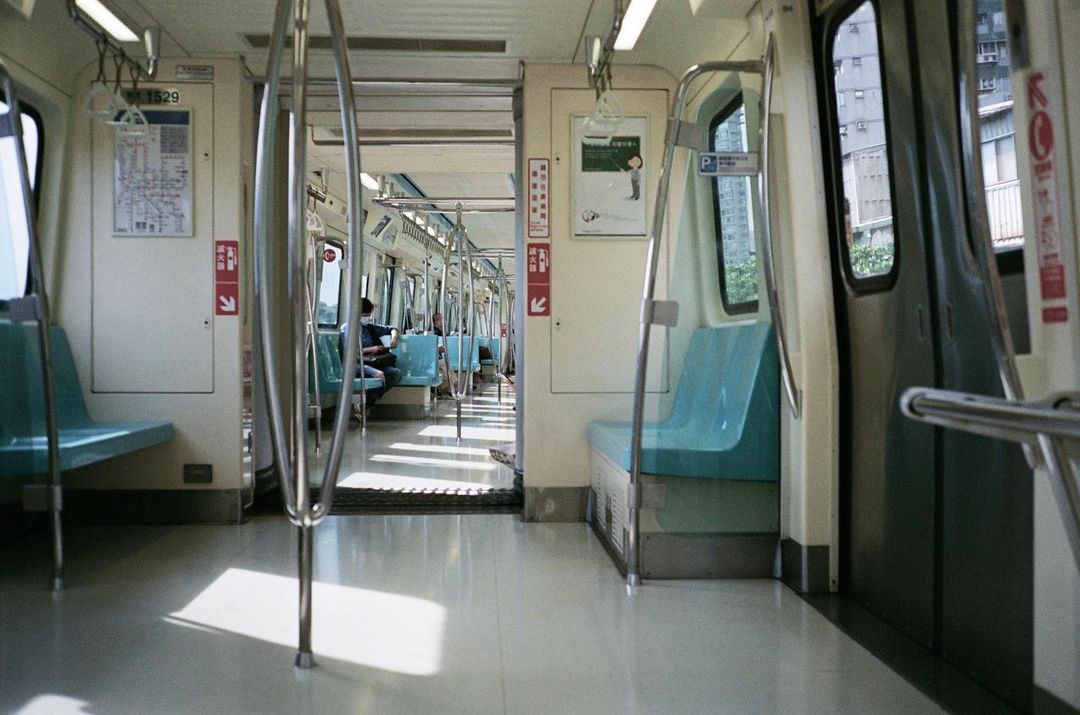 Interior of a Taiwan metro train with seating and a few passengers inside the carriage