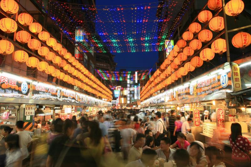 colorful lights, and a crowd of people enjoying food stalls