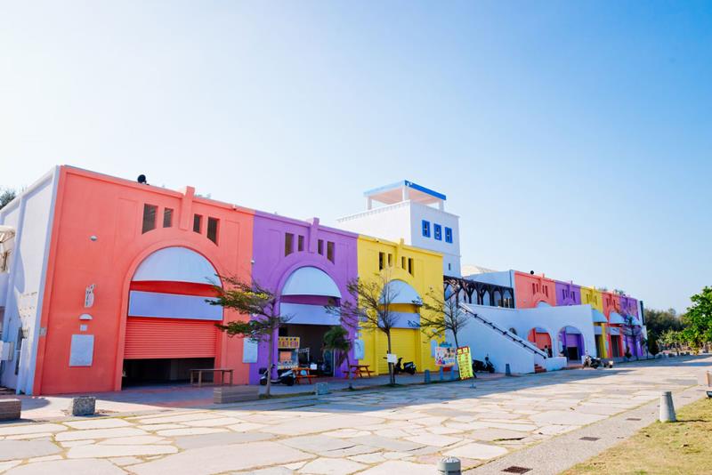 Colorful row of buildings featuring red, purple, and yellow facades