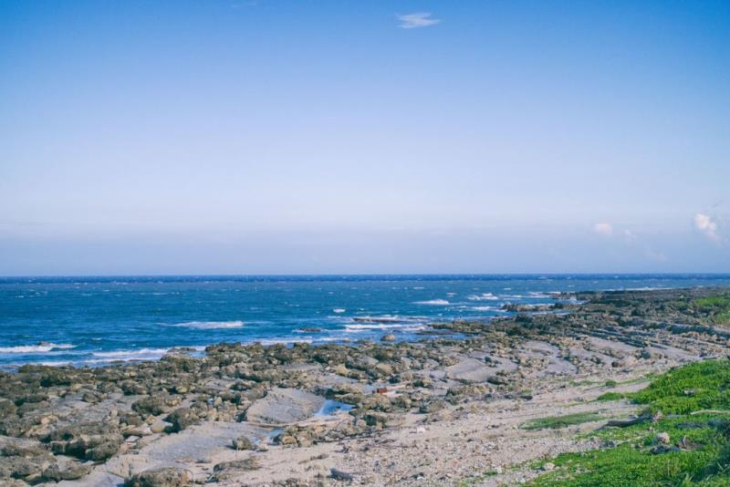 Rocky shoreline with calm blue ocean under a clear sky