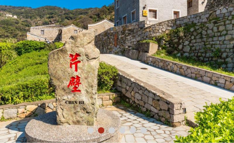 Stone monument with red Chinese characters engraved, set on a paved path