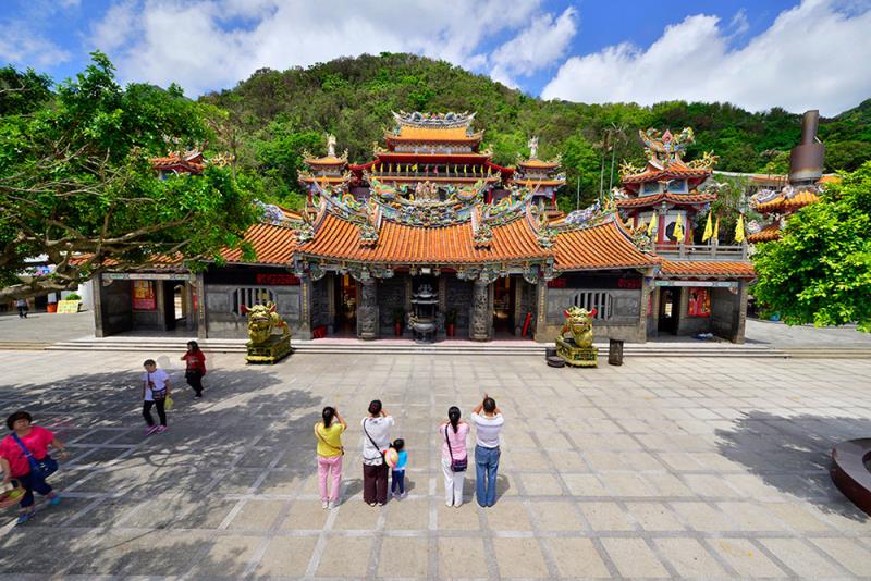 A colorful temple with intricate designs and orange tile roofs