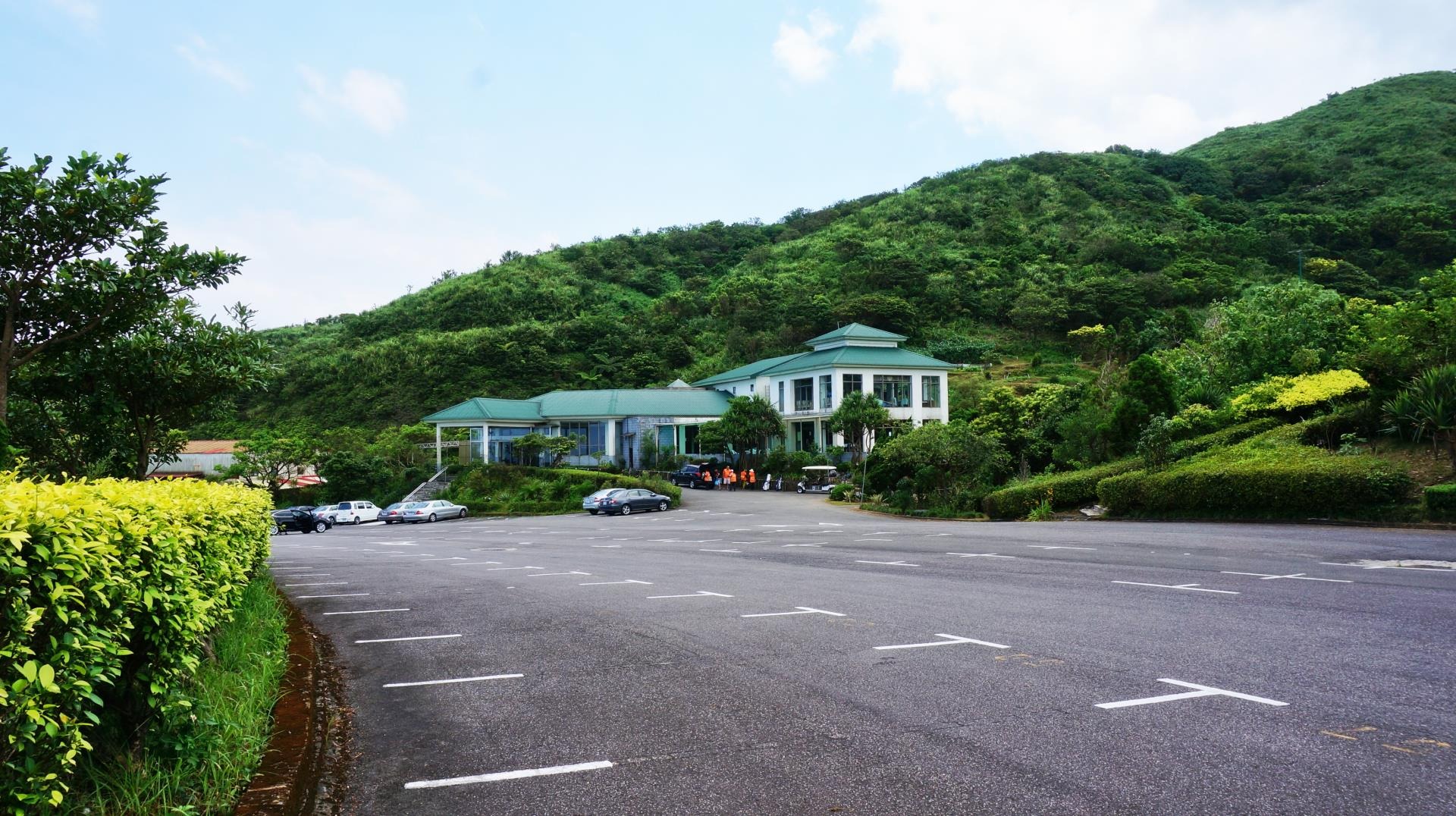 resort or lodge nestled against a heavily forested green mountain slope