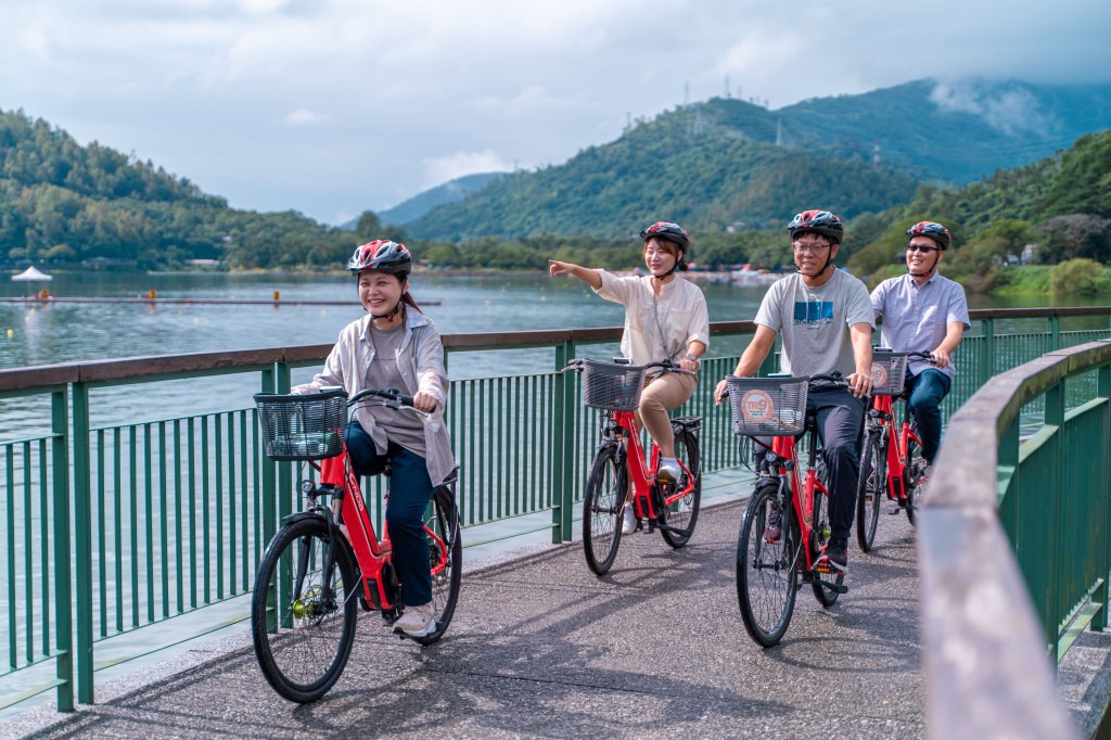 people enjoying a scenic bicycle ride along a paved lakeside path