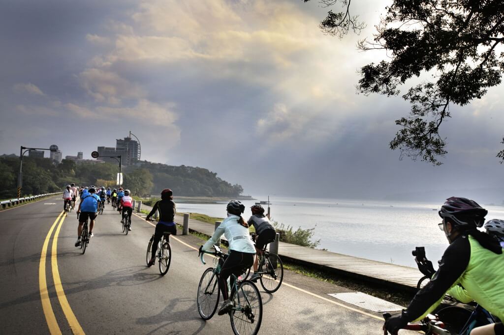 cyclists riding along the scenic lakeside path