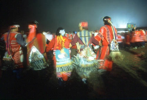 Native American dancers wearing traditional regalia