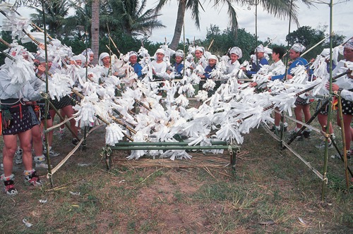 Catholic parishioners wearing elaborate, feathered birdlike costumes