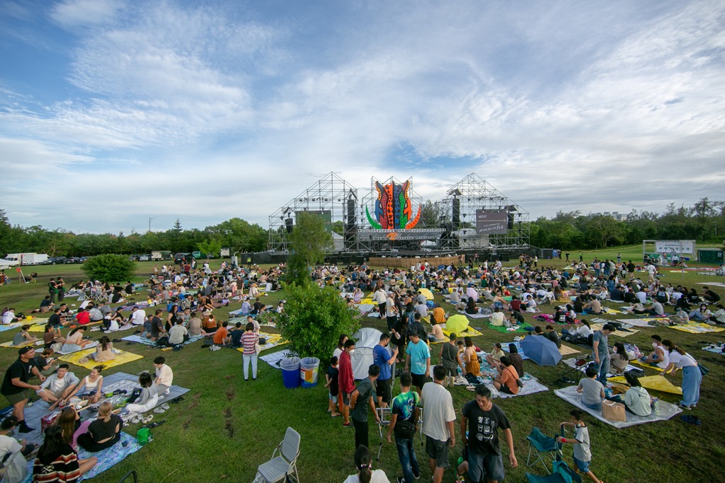 outdoor community festival or concert taking place on a grassy park field
