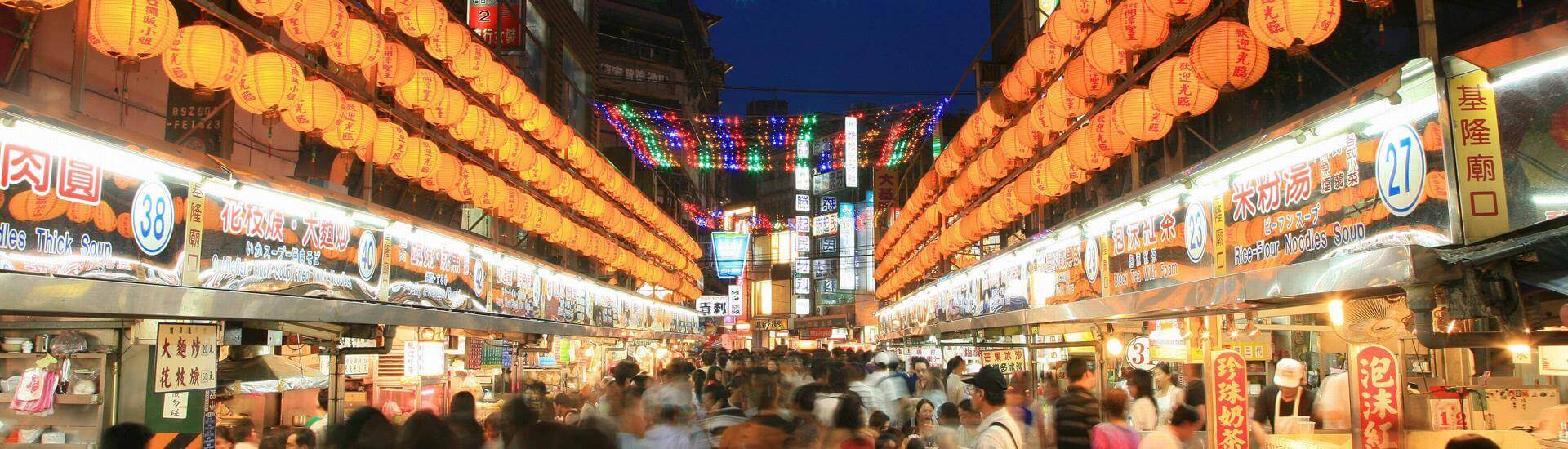 Illuminated traditional temple architecture against the evening sky in Taiwan.
