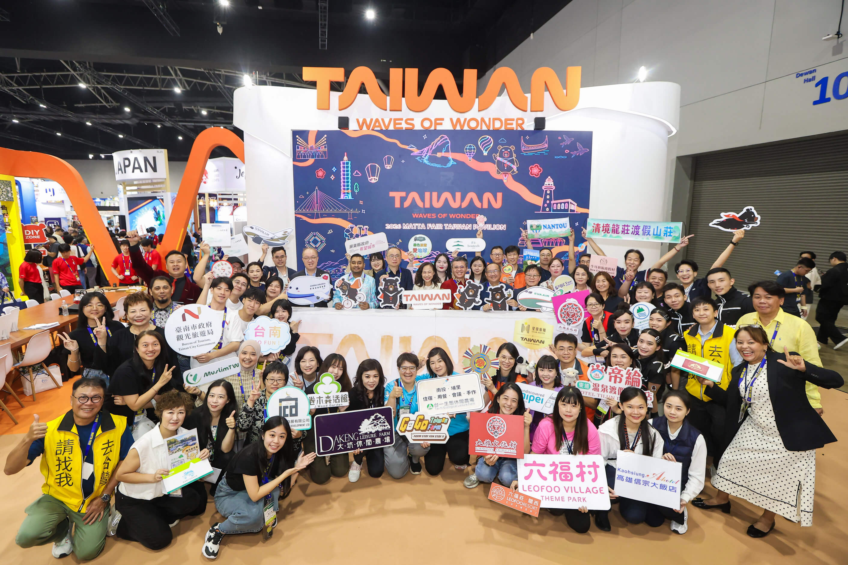 Taiwan Tourism Board representatives and partners holding promotional signs together on stage.